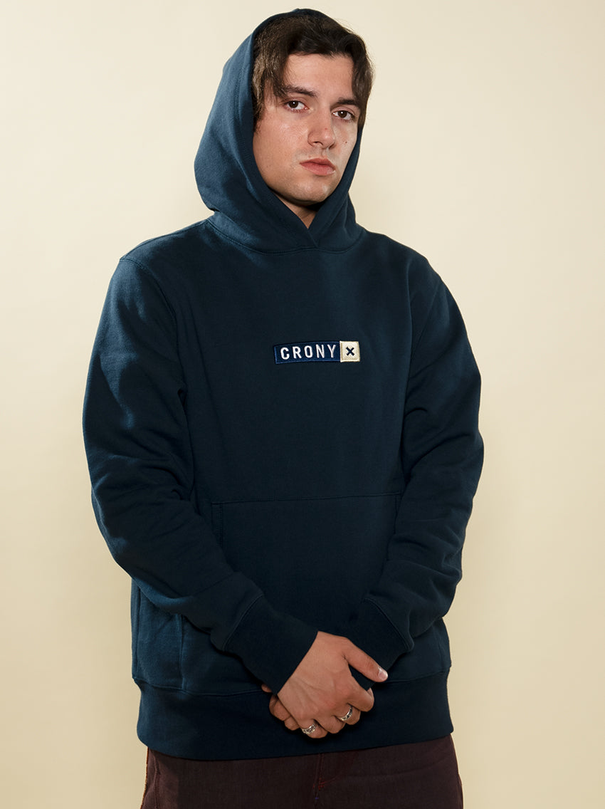 Male model wearing navy CRONY X branded hoodie. These are made of premium, organic cotton giving it a soft, comfortable feel