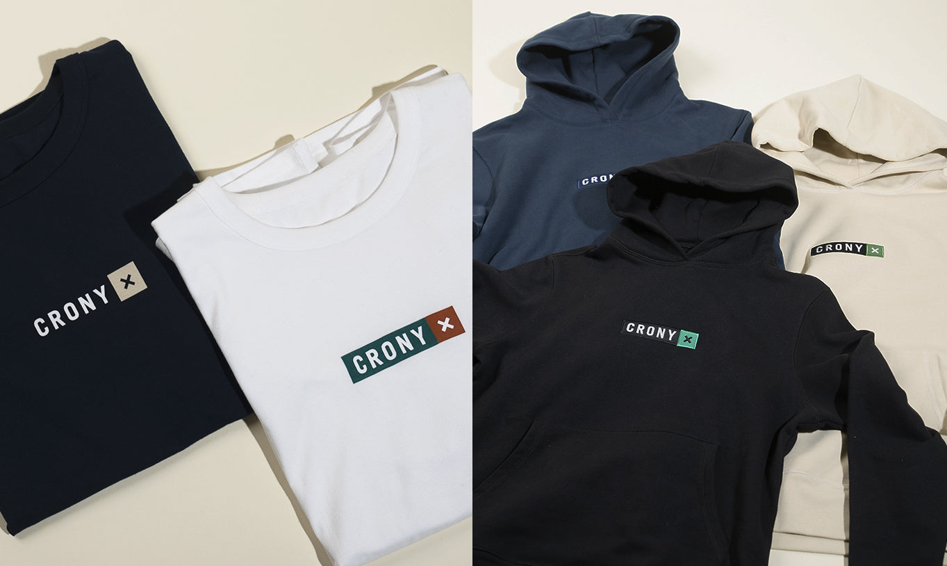 CRONY X tees and hoodies, made from organic cotton, are laid out and folded. These are manufactured using sustainable and ethical practices