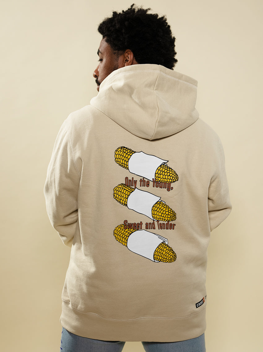 Back side view of a male model wearing the Young, Sweet, Tender hoodie created by maker Brent Lamb. This has corn on the cob with the wording "Only the young, sweet and tender". This hoodie is made of high quality organic cotton to give a warm and comfortable feel