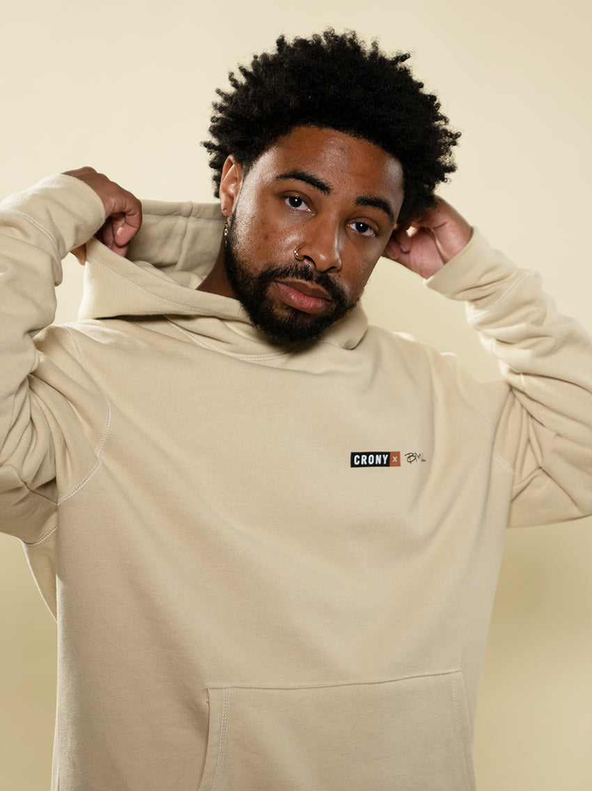 Male model wearing the Young, Sweet, Tender hoodie created by maker Brent Lamb. The front has the CRONY X logo with Brent's initials next to it. This hoodie is made from high quality organic cotton to give a warm and comfortable feel