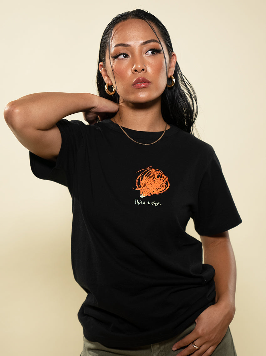 Female model wearing the This is Burnt tee created by maker Brent Lamb. This tee is made of high quality organic cotton for a soft and comfortable feel